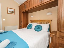 A bedroom with a bed and storage units at Kingfisher Lodge in Windermere