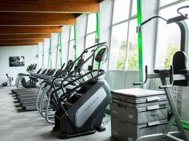 A gym with exercise equipment and large windows at Kingfisher Lodge in Windermere