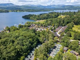 An aerial view of a lakeside property with wooden houses and boats at Kingfisher Lodge in Windermere