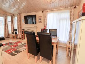 A dining room with a table and chairs at Kingfisher Lodge Grasmere 33, White Cross Bay near Windermere