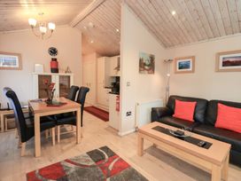 A living room with a dining area and sofa at Kingfisher Lodge Grasmere 33, White Cross Bay near Windermere
