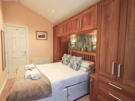 A bedroom with a bed and wardrobe at Kingfisher Lodge, Grasmere 33, White Cross Bay near Windermere