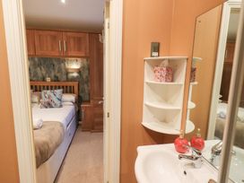A bedroom with a bed and sink at Kingfisher Lodge Grasmere 33, White Cross Bay near Windermere