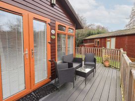 A deck area with chairs and a table at Kingfisher Lodge Grasmere 33, White Cross Bay near Windermere