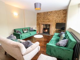 A living room with green sofas and a fireplace at The Old Bakery in Banbury
