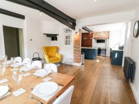 A dining room with a table and chairs leading to a kitchen at The Old Bakery in Banbury