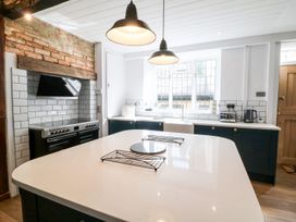A kitchen with an island, stove and sink at The Old Bakery in Banbury