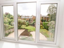 A view from a window showing a garden and houses at The Old Bakery in Banbury