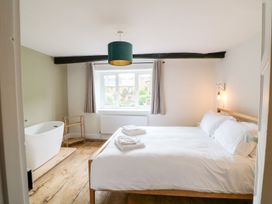 A bedroom with a bed and a bathtub at The Old Bakery in Banbury