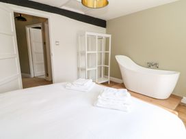 A bedroom featuring a bed with towels and a bathtub at The Old Bakery in Banbury