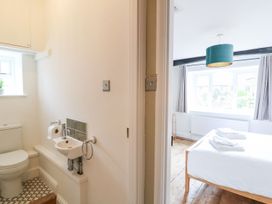 A bathroom and bedroom area with a bed and sink at The Old Bakery in Banbury
