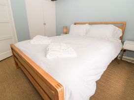 A bedroom with a bed, towels, and bedside lamp at The Old Bakery in Banbury