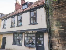A building exterior with windows and a sign at Stowaway Cottage in Whitby