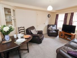 A living room with seating and a television at Stowaway Cottage in Whitby