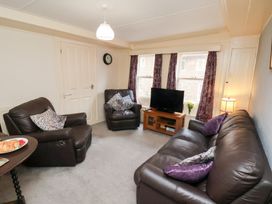 A living room with a sofa and television at Stowaway Cottage in Whitby