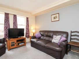 A living room with a television and sofa at Stowaway Cottage in Whitby
