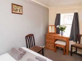 A bedroom with a bed and desk at Stowaway Cottage in Whitby