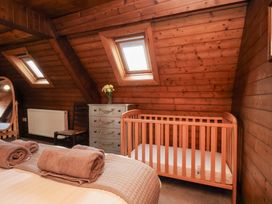 A bedroom with a crib and a dresser at Stowaway Cottage in Whitby