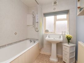 A bathroom with a bathtub and sink at Stowaway Cottage in Whitby