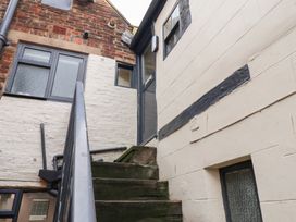 Stairs leading to a door with windows at Stowaway Cottage in Whitby