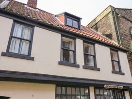 An exterior view of a building with windows and a chimney at Stowaway Cottage in Whitby