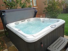 A hot tub with a cover and steps at Fern Lodge Stowmarket