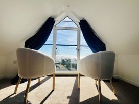 An attic space with two chairs and a window at 2A Hamilton Road in Felixstowe