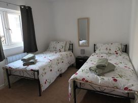 A bedroom with two beds and a mirror at 2B Hamilton Road in Felixstowe