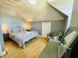 A bedroom with a bed and armchair at 11 Langer Road in Felixstowe