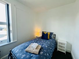 A bedroom with a single bed and a bedside table at 11 Langer Road in Felixstowe