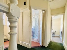 A hallway with a shower area and rooms on either side at 11 Langer Road Felixstowe