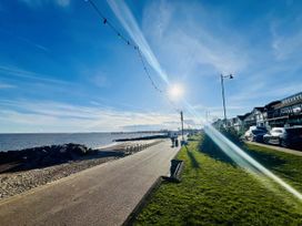 A coastal scene with a pathway beside the sea at 11 Langer Road in Felixstowe