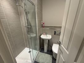 A bathroom with a shower and a sink at 14 Becket Close in Woodford Green