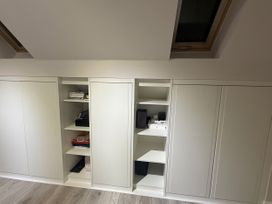 An office with cabinets and shelves containing books and a printer at 14 Becket Close Woodford Green