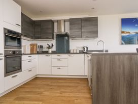 A kitchen with cabinets and appliances at Praa Waves in Penzance