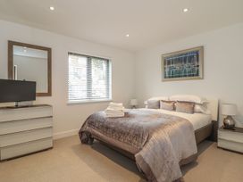 A bedroom with a bed, television, and dresser at Praa Waves in Penzance