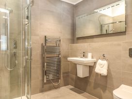 A bathroom with shower, sink, toilet and towel rail at Praa Waves in Penzance