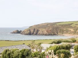 A view of the coastline with rocks and vegetation at Praa Waves in Penzance