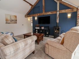 A living room with a fireplace and tv at Pillar Barn in Driffield