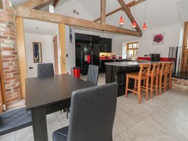 A kitchen with a dining area and bar stools at Pillar Barn Driffield