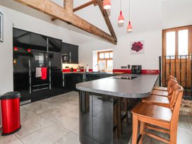 A kitchen with a kitchen island and bar stools at Pillar Barn Driffield
