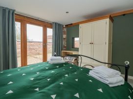 A bedroom with a bed and wardrobe at Pillar Barn Driffield