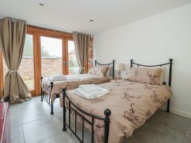 A bedroom with two beds and sliding doors at Pillar Barn Driffield