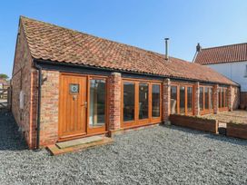 An outdoor area with a brick building and wooden features at Pillar Barn Driffield