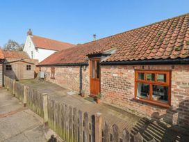 An outdoor area with a brick wall and garden shed at Pillar Barn in Driffield