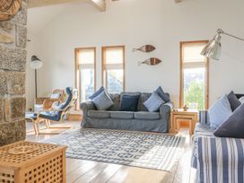 A living room with sofa, chairs and windows at Harbour Lights in Penzance