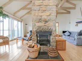 A living room with a fireplace and sofa at Harbour Lights in Penzance