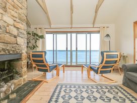 A living room with two chairs and a fireplace at Harbour Lights in Penzance