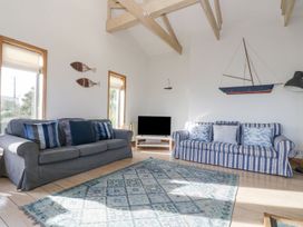 A living room with a television and sofas at Harbour Lights in Penzance