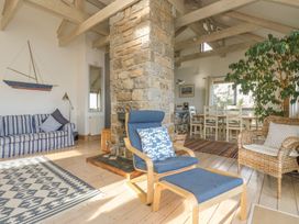 A living room with a stone chimney and dining area at Harbour Lights in Penzance